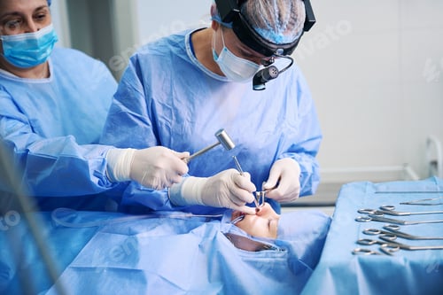 Preview: Clinic employee assists a surgeon