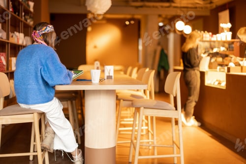 Preview: Woman works on touchpad at coffee shop