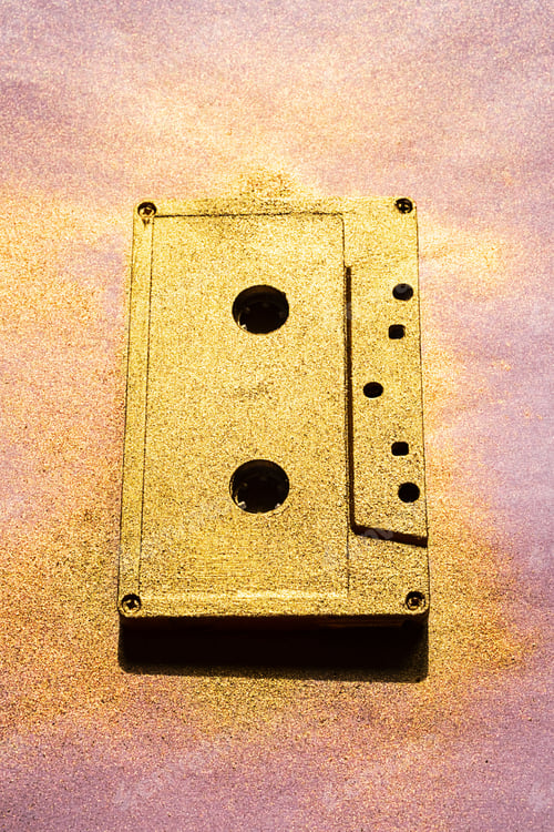 Preview: Vintage Golden Colour Audio Cassette. Old Cassette Tape on Pink.