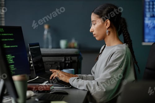 Preview: Middle Eastern Female Programmer Using Laptop Coding on Computer at Desk in Office