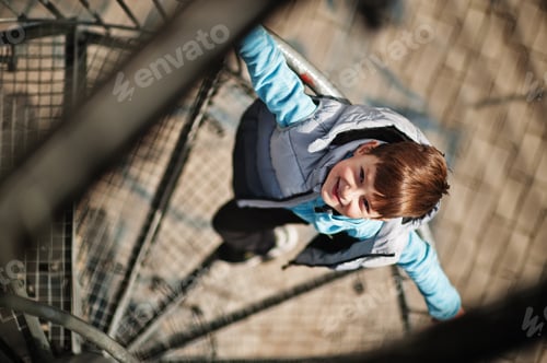 Preview: Boy stand at spiral staircase on observation tower.