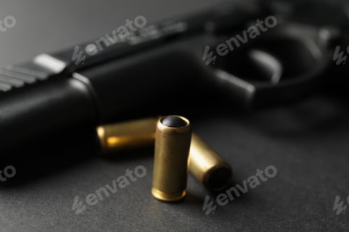 Preview: Pistol and traumatic bullets on black background. Self defense weapon