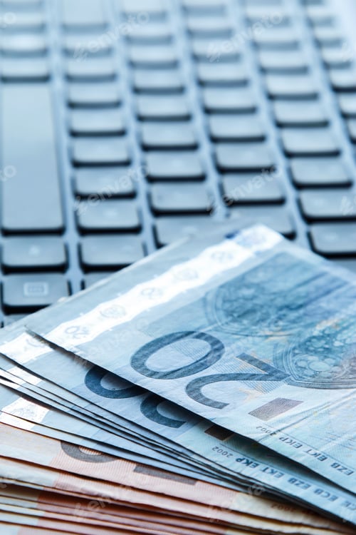 Preview: Banknotes over laptop keyboard