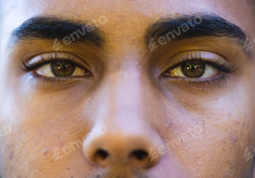 Preview: Close up of brown eyes of biracial man looking at camera