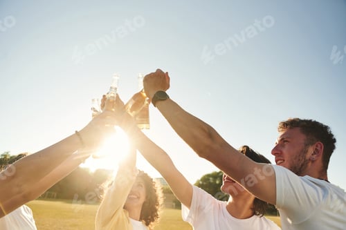 Preview: Party time, celebration. People are celebrating by cheering with beer bottles