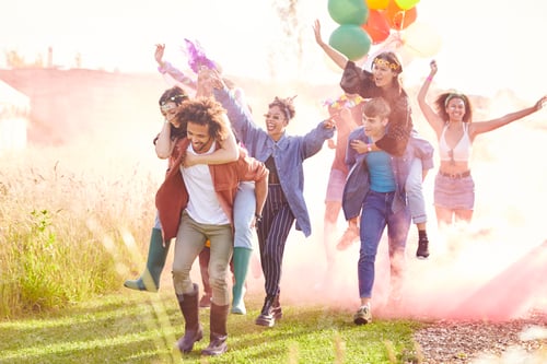 Preview: Group Of Friends Walking Back To Tent After Outdoor Music Festival With Balloons And Smoke Flare