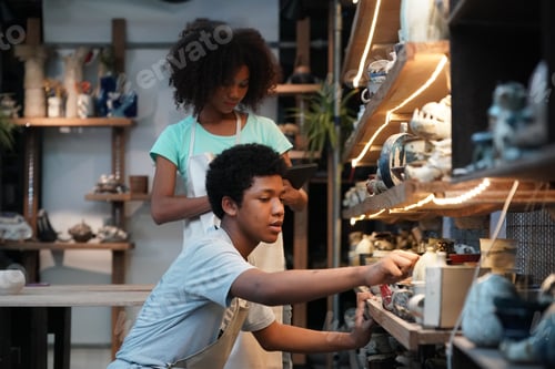 Preview: Young Woman hand potter making clay vase in pottery workshop, Business owner.
