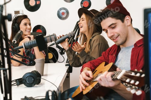 Preview: Image of young happy caucasian people performing at radio program