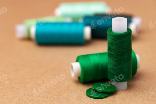 Preview: Thread spools and buttons on beige background