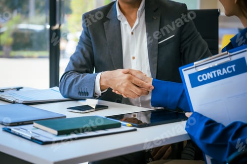 Preview: A middle-aged businessman woman work together at desk in an office,engaged professional discussion