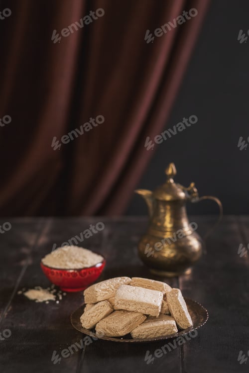 Preview: Pieces of tahini halva, sesame seeds in a bowl, an vintage jug.
