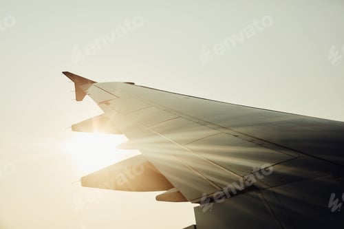 Preview: Lets fly away. Cropped shot of an airplanes wing in mid flight.