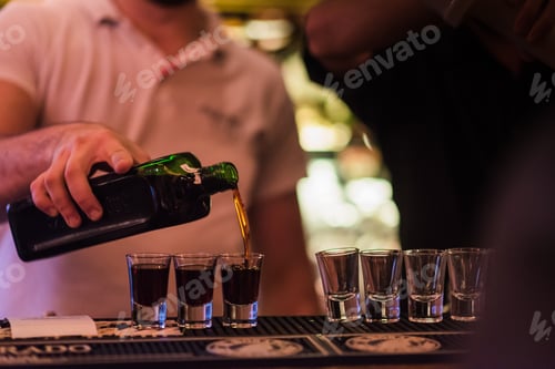 Preview: Bartender pouring shots in glasses