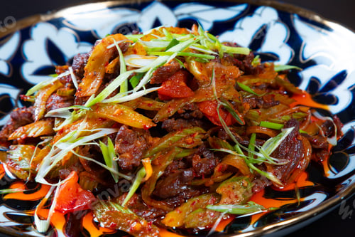 Preview: Closeup of plate with chopped meat and vegetables on a black background. Asian cuisine