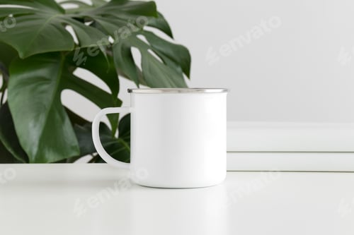 Preview: Enamel mug mockup with workspace accessories and a monstera plant.