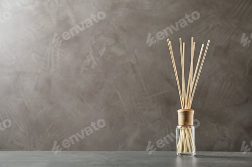 Preview: Reed air freshener on table against brown background, space for text