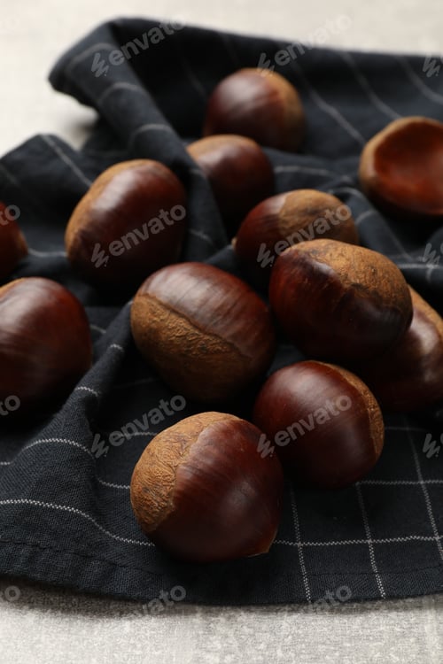 Preview: Roasted edible sweet chestnuts on light table, closeup