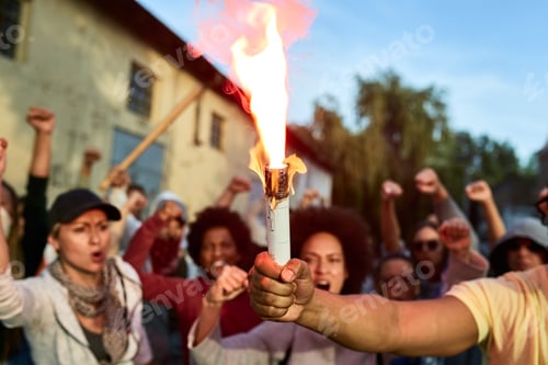 Preview: Close-up of human rights activist holding inflamed torch on public demonstrations.