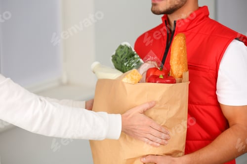 Preview: Male courier delivering food to client indoors, closeup