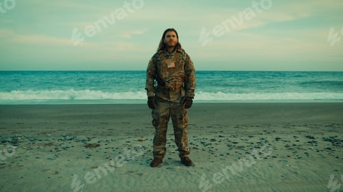 Preview: American Navy soldier performs a jumping jack exercise on the beach near ocean