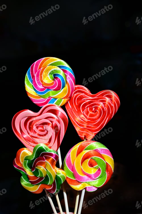 Preview: Top view of three multicolored lollipops isolated on dark blue background. Pin-up style