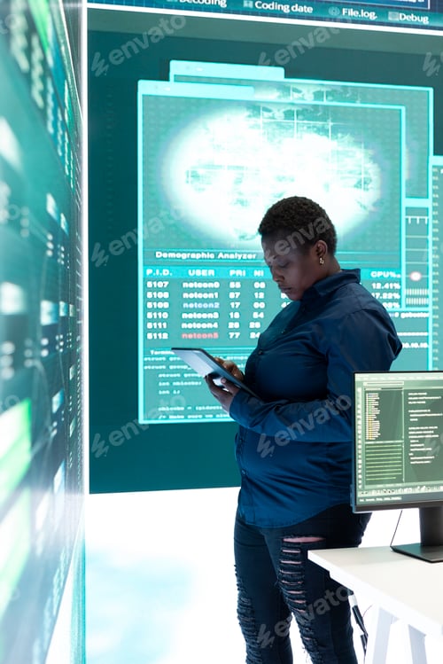Preview: Governmental hacker woman working with a tablet and big screen