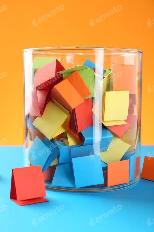 Preview: Bright paper pieces in glass jar on color background, closeup