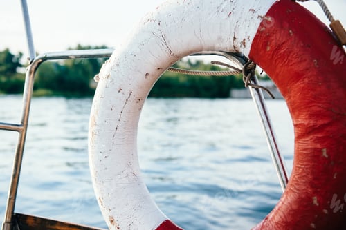 Preview: old lifebuoy in red and white on the yacht