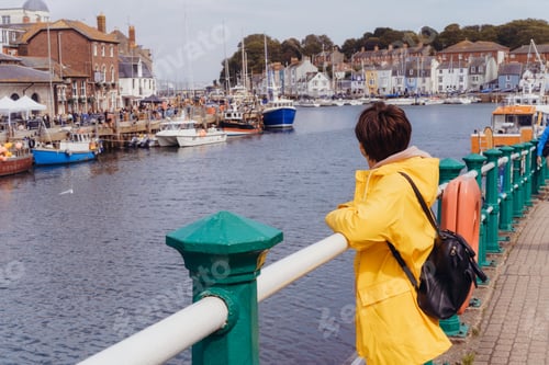 Preview: Woman enjoying the view of the bay with ships and boats. Local travel. Waymouth, England