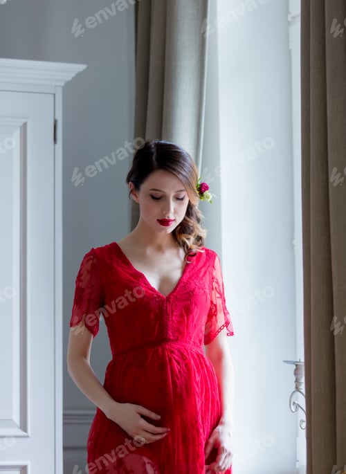 Preview: Young woman in red dress standing in room