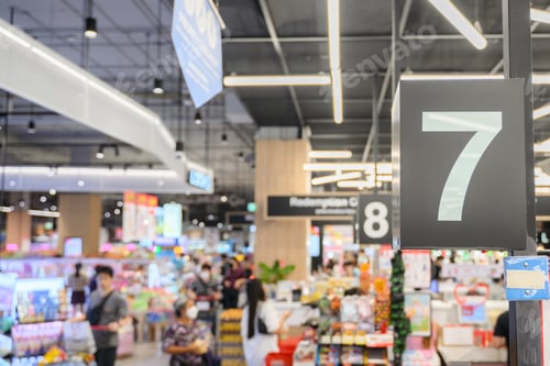 Preview: Young adult woman using phone in grocery store