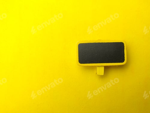 Preview: Colored wooden board on a yellow background. The concept of copy space for writing