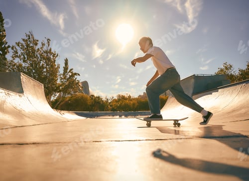 Preview: Full body of young male skater in casual outfit doing trick on skateboard riding in