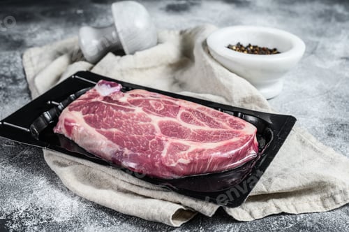 Preview: Unopened vacuum pack of pork steak isolated on black background, without label. Gray background