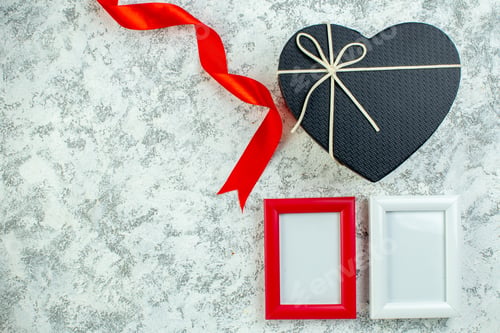 Preview: top view heart gift box red ribbon frames on grey table free space