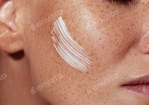 Preview: Close-up shot of female skin with freckles with white cream