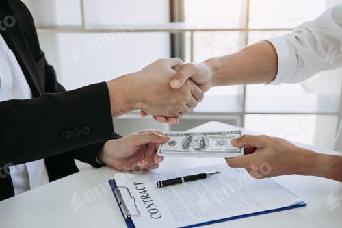 Preview: corporate businessmen shaking hands while one man places money on document