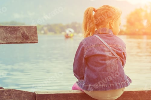 Preview: Little Girl Sitting On A Pier Near The Lake.