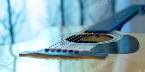 Preview: Acoustic guitar on a beautiful colored background. The concept of stringed instruments.
