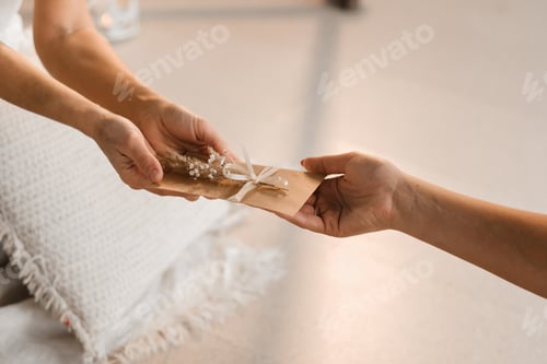 Preview: A woman in white clothes passes an envelope with a wish to another woman.