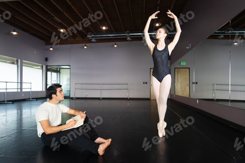 Preview: Artist draws in his sketch book as a ballerina model poses in a dance studio