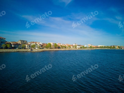 Preview: Promenade with people walking near Black Sea against backdrop of town Pomorie in Bulgaria