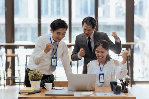 Preview: Business success. Group of young asian business people is receiving good news online, raising hands.