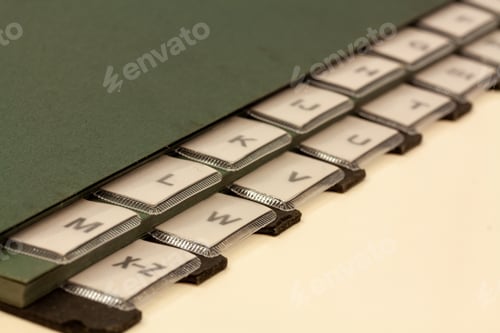 Preview: Closeup shot of part of a black folder with letters on a white background