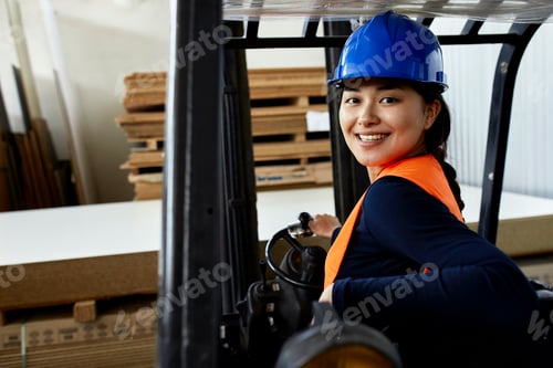 Preview: Portrait of confident female worker on forklift in factory