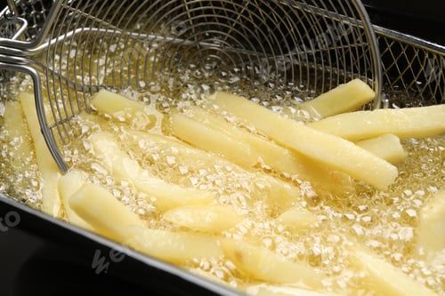 Preview: Cooking delicious french fries in hot oil, closeup