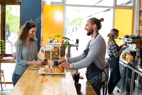 Preview: Waiter serving a cup of coffee to customer at counter