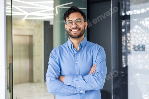 Preview: Confident young professional standing in modern office with arms crossed