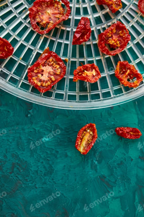 Preview: Homemade sun dried tomatoes with herbs, on the sieve from dryer.