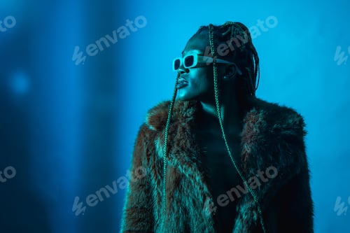 Preview: Attractive black ethnic woman with braids with blue led lights, copy paste in fur coat